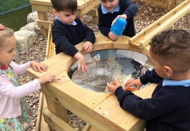 Nursery and Reception pupils playing with water table at The Lea Primary School and Nursery